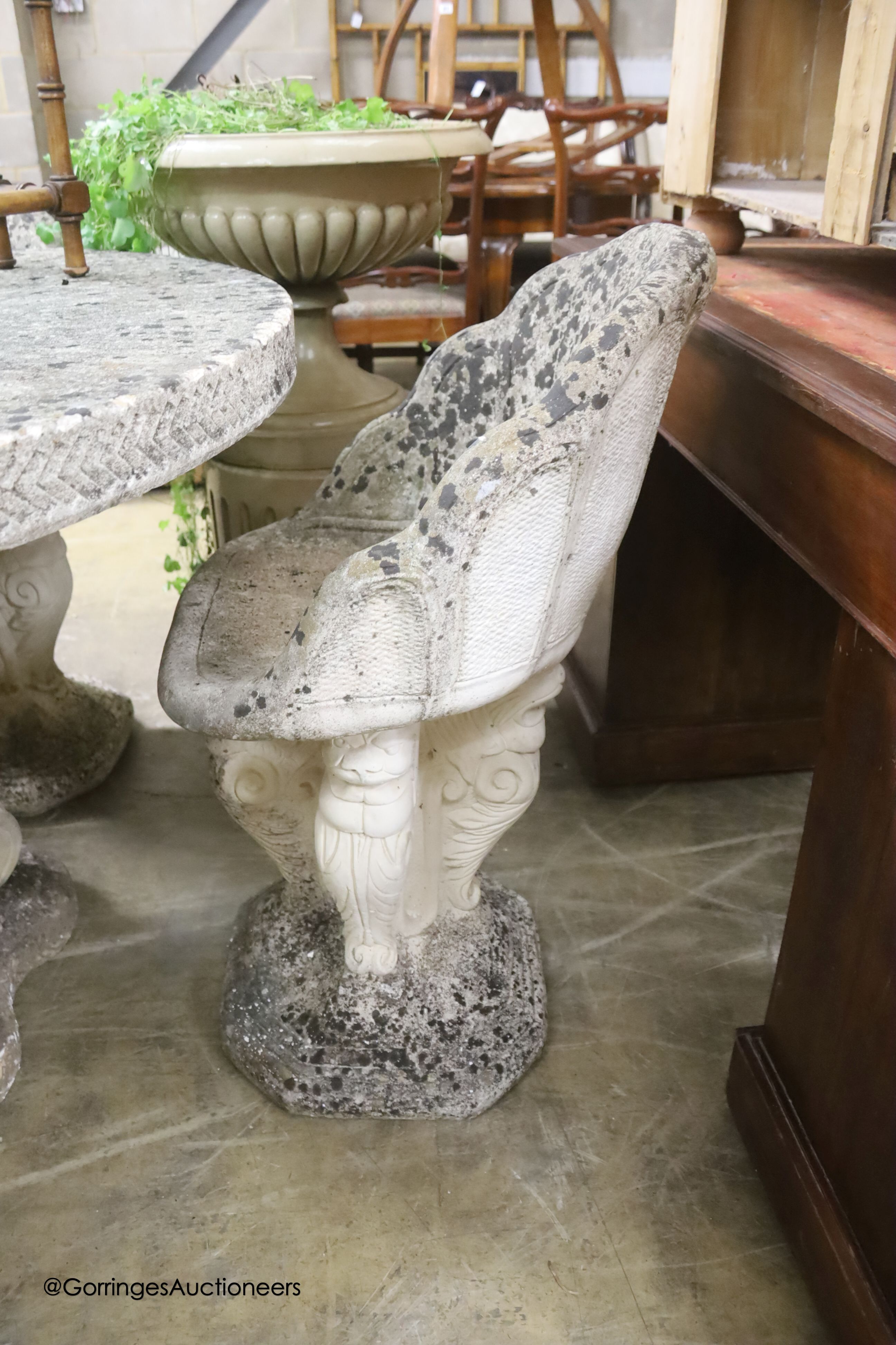A circular reconstituted stone circular garden table, diameter 114cm, height 79cm and four matching chairs